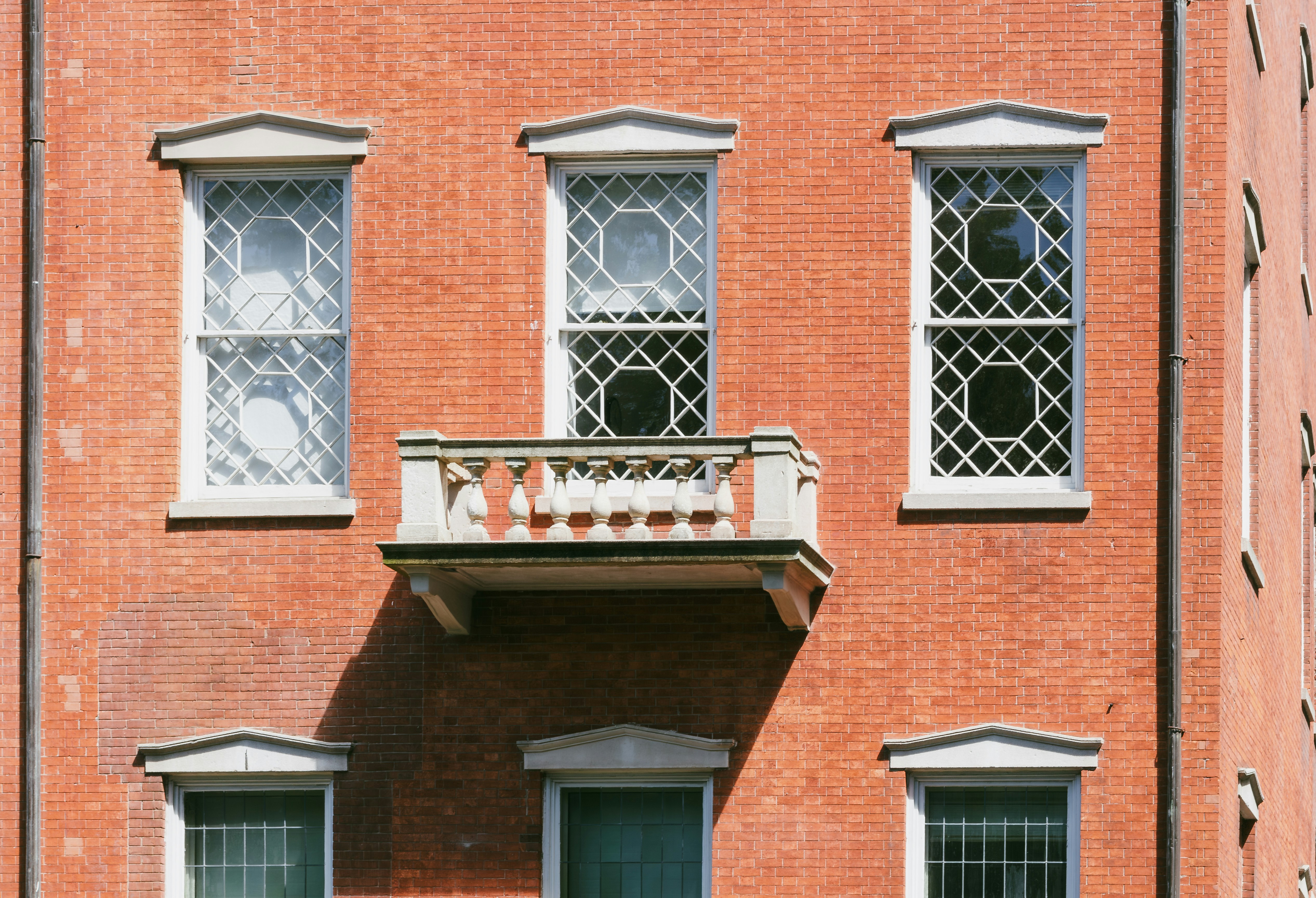 Un edificio de ladrillo rojo con dos ventanas y un balcón