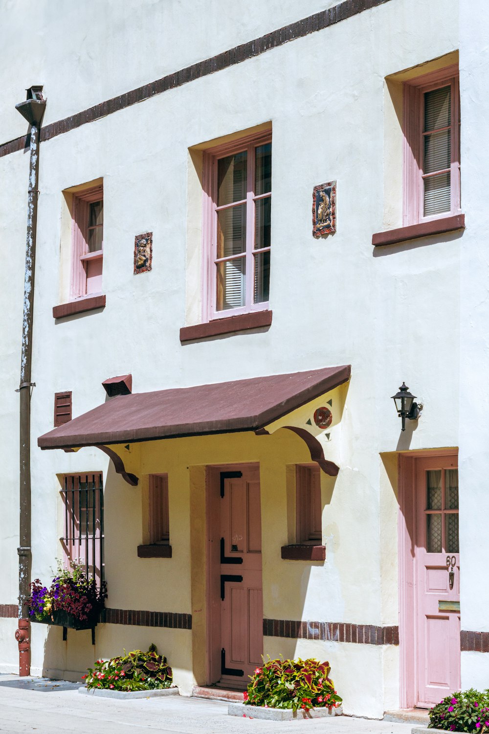 a white building with pink doors and windows