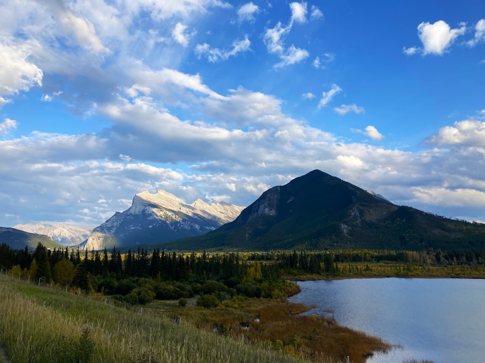 a scenic view of a mountain range with a lake in the foreground