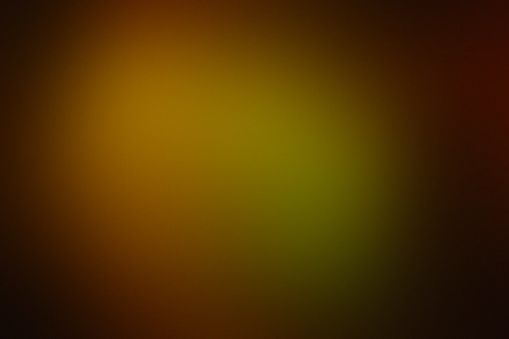 a blurry image of a red, yellow, and green background