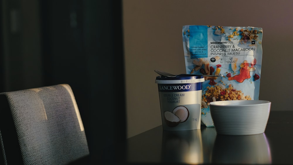 a bag of cereal and a cup on a table