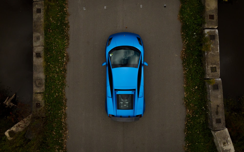 a blue sports car is parked on the side of the road