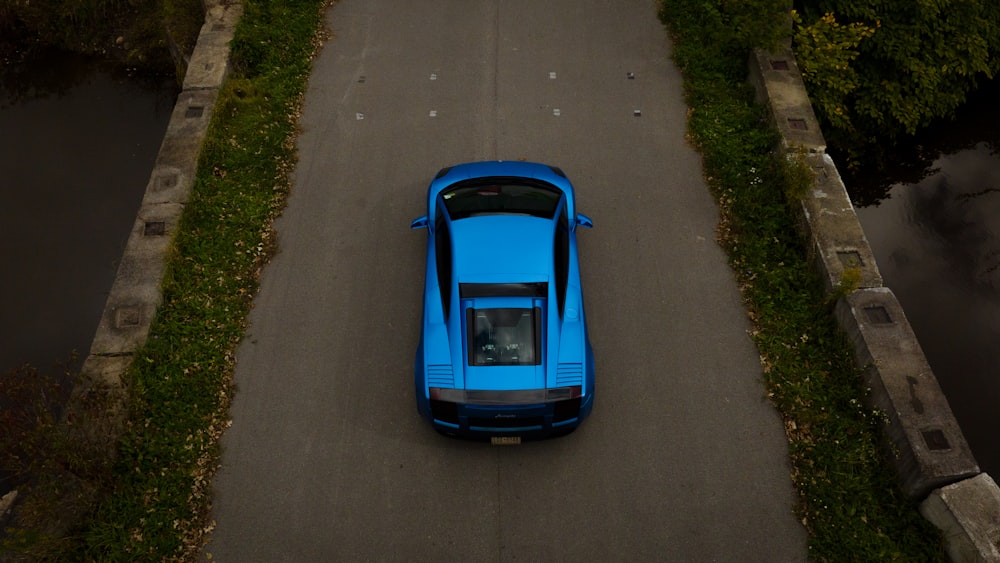 a blue sports car parked on the side of a road