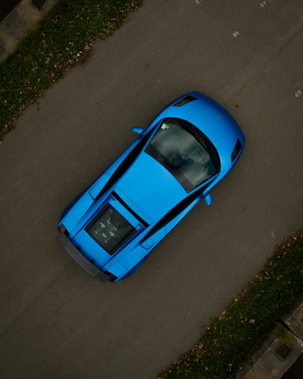 a blue sports car parked on the side of the road