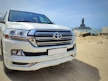 a white toyota land cruiser parked on the beach