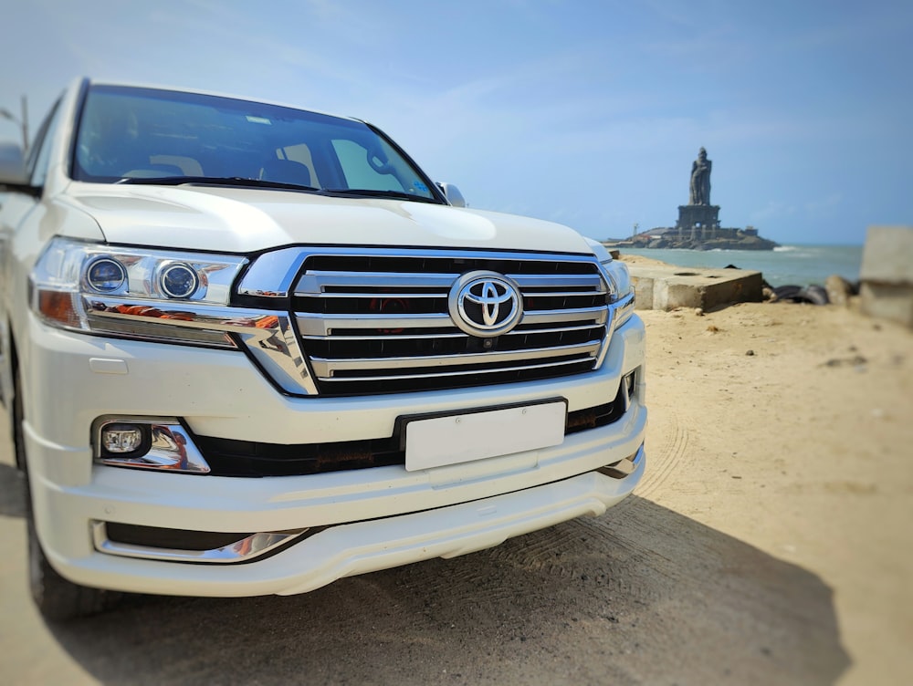 a white toyota land cruiser parked on the beach