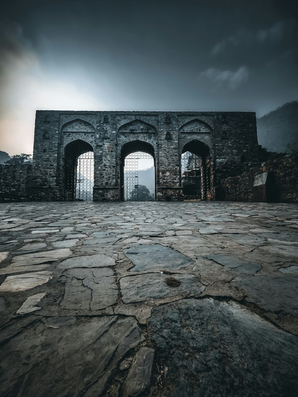 an old stone building with two arched doors