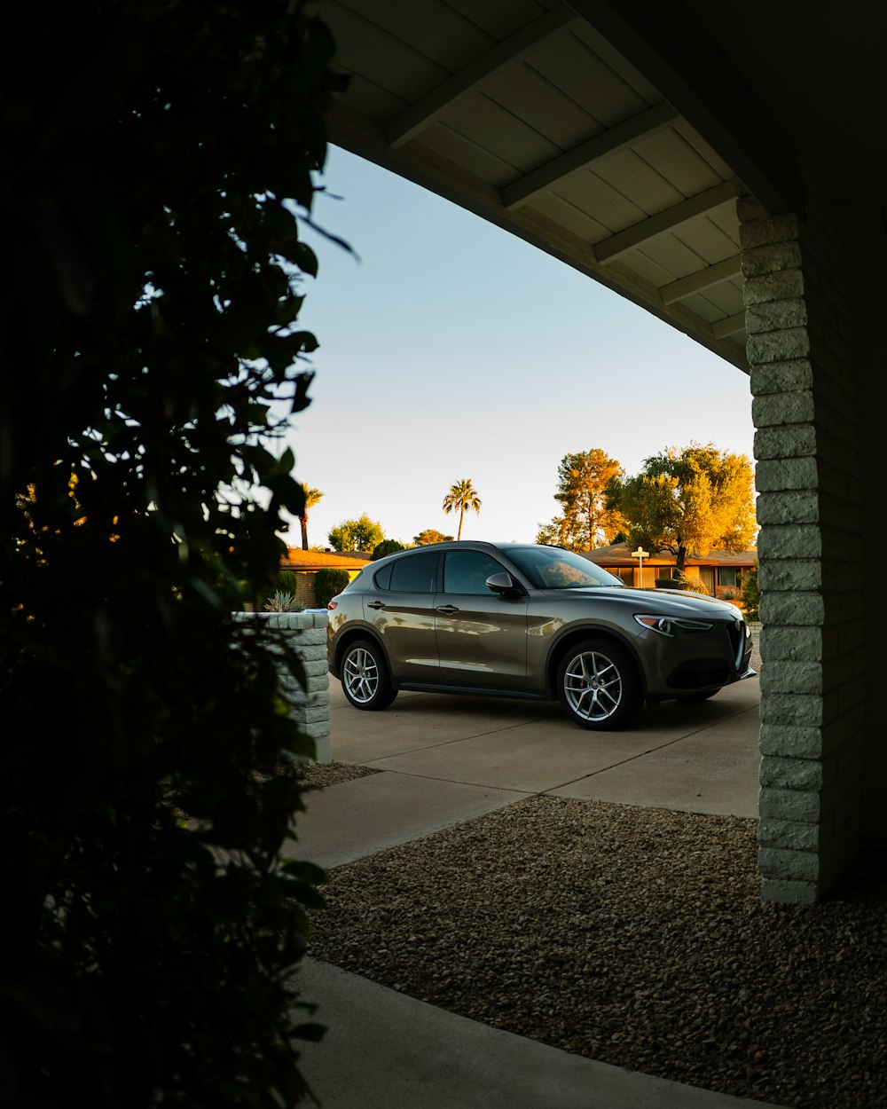 a car parked in a driveway under a bridge