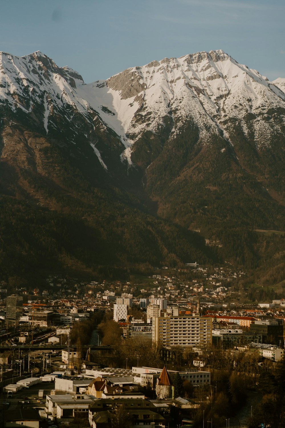 a view of a city with snow covered mountains in the background