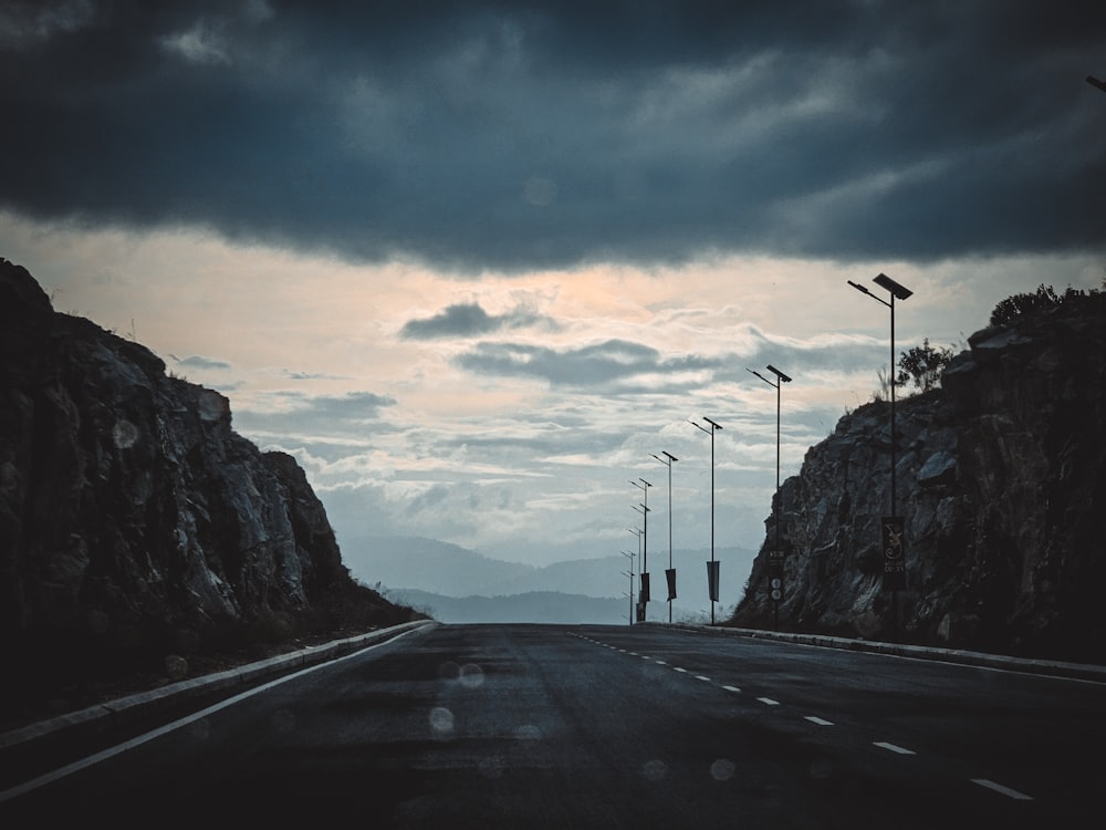 a dark road with a mountain in the background