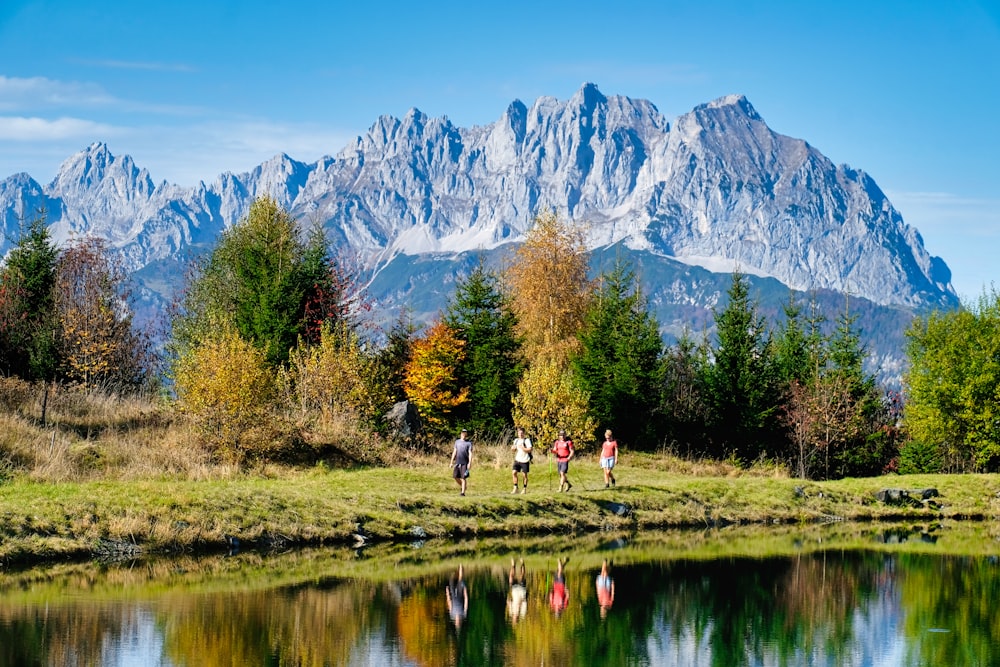 a group of people walking across a lush green field