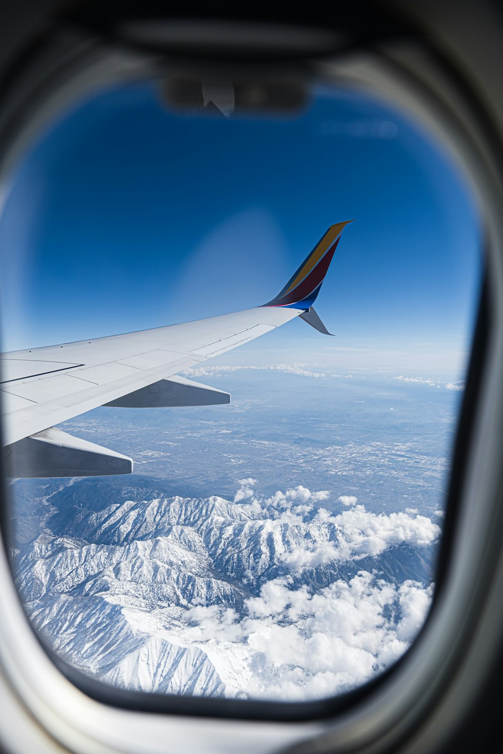 a view of the wing of an airplane over a mountain range