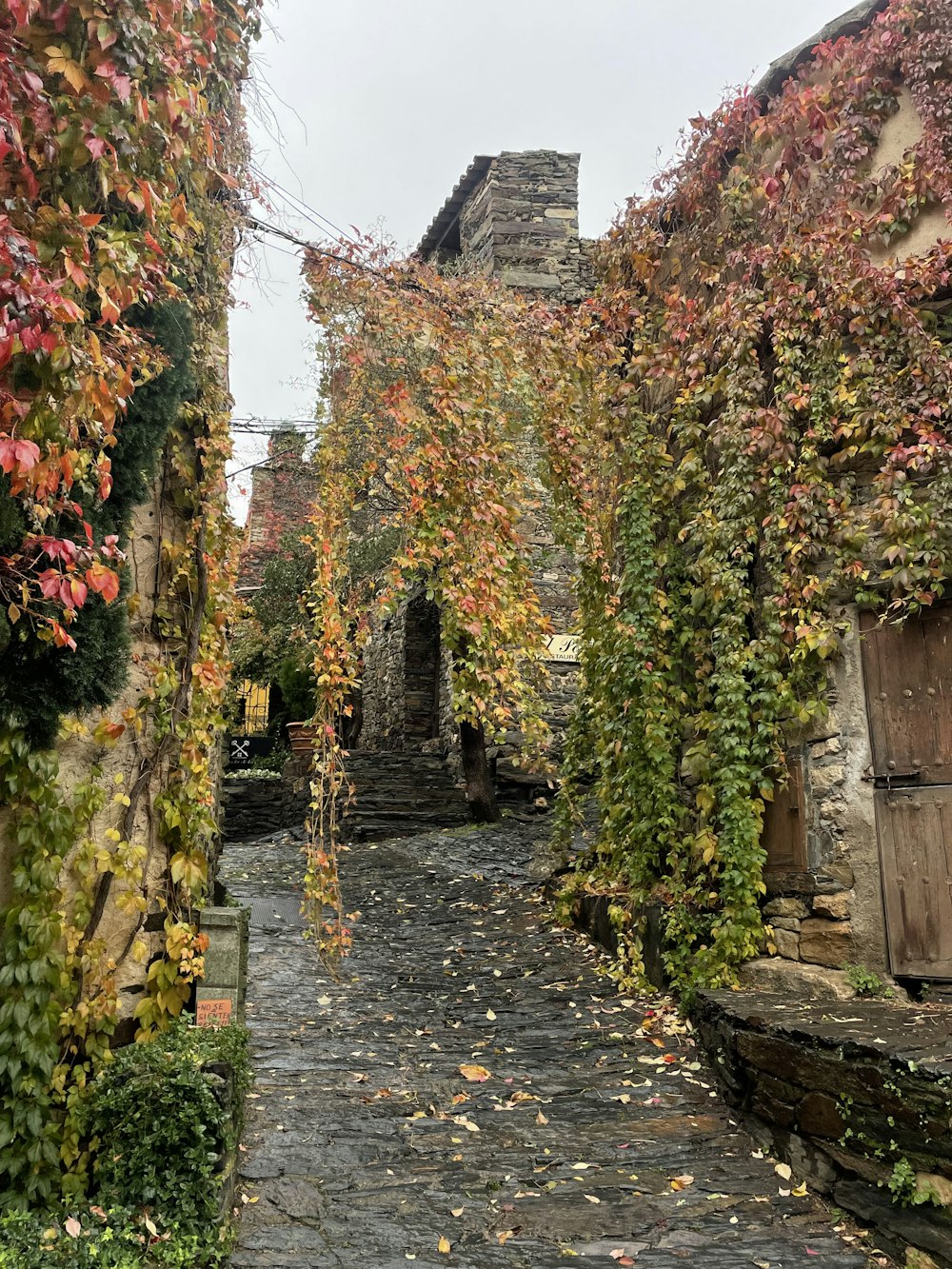 a cobblestone road with a stone building in the background