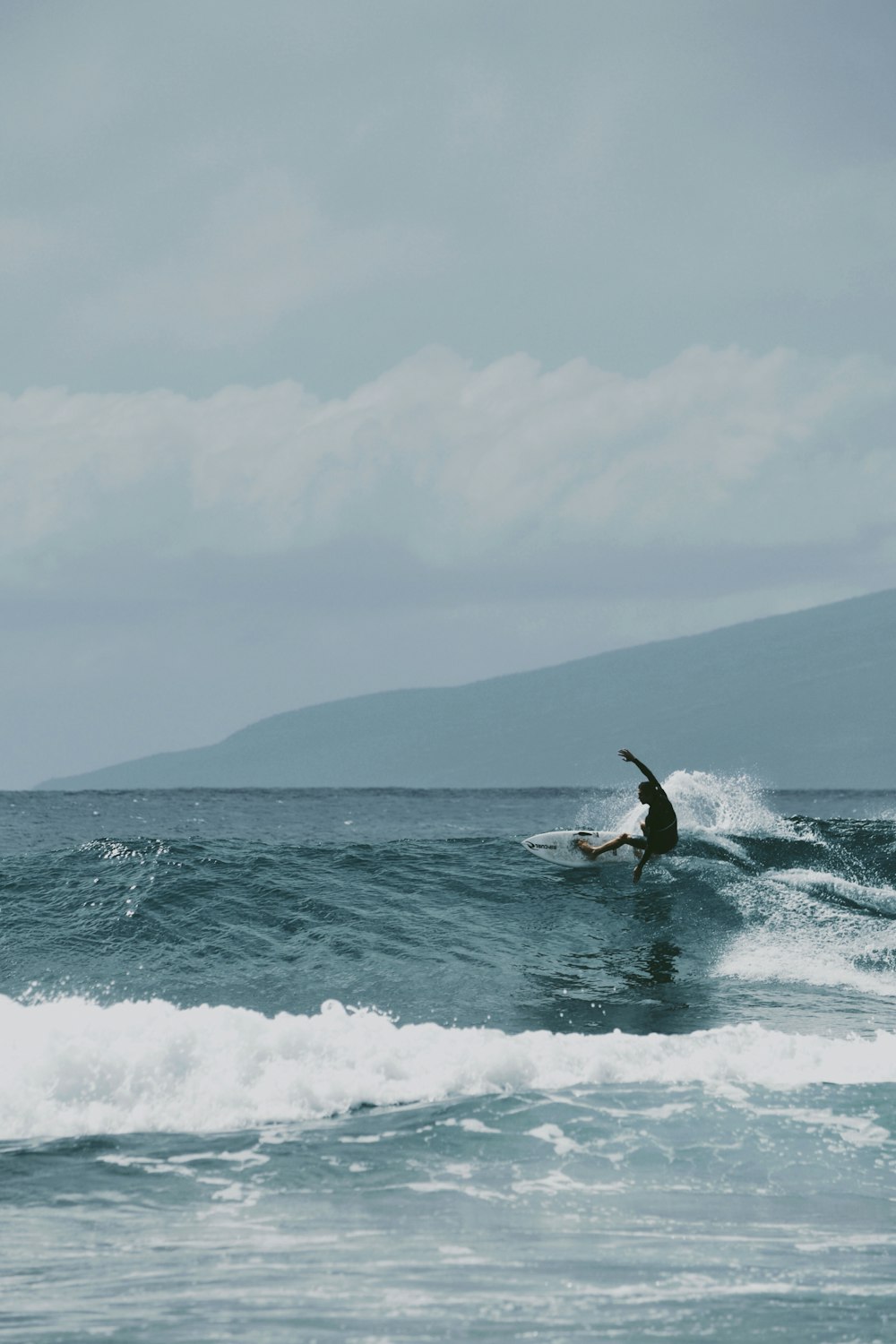 um homem surfando uma onda em cima de uma prancha de surfe