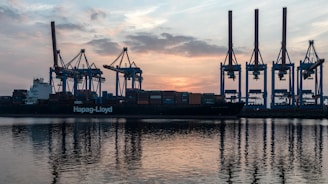 a large cargo ship in a harbor at sunset