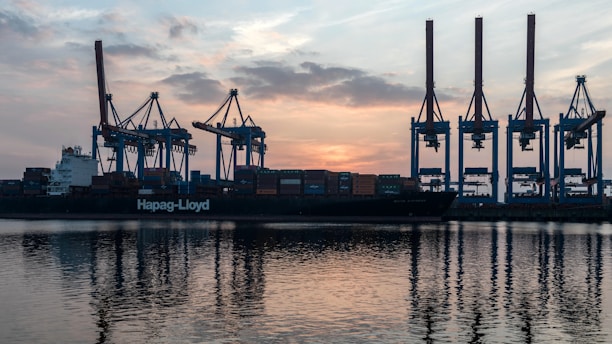 a large cargo ship in a harbor at sunset