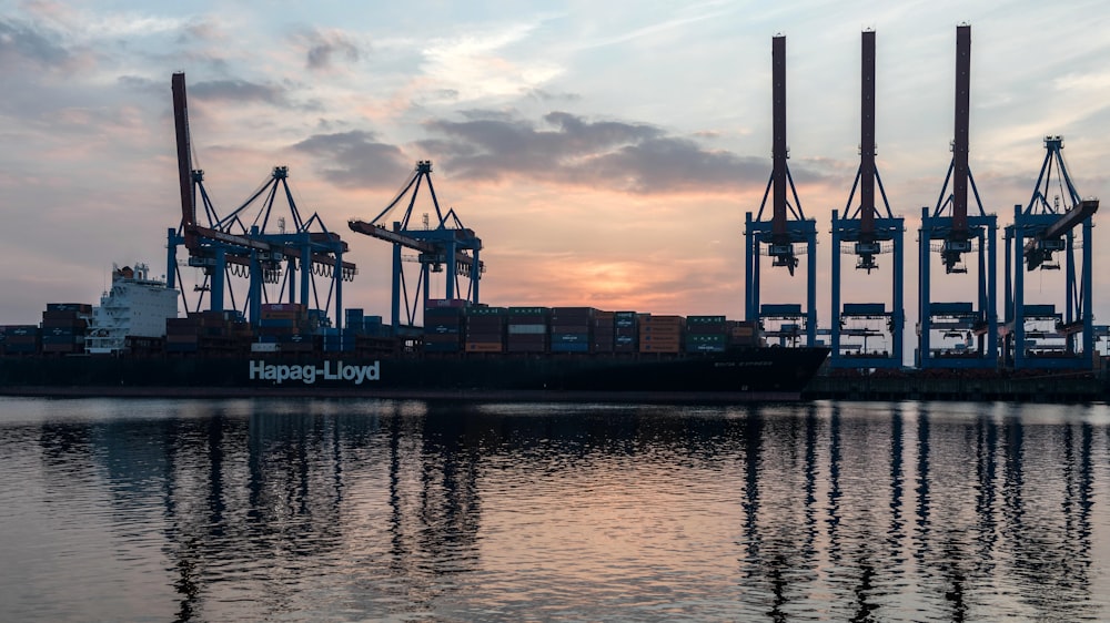 a large cargo ship in a harbor at sunset