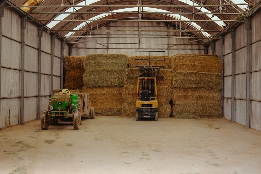 a warehouse with hay bales and a tractor