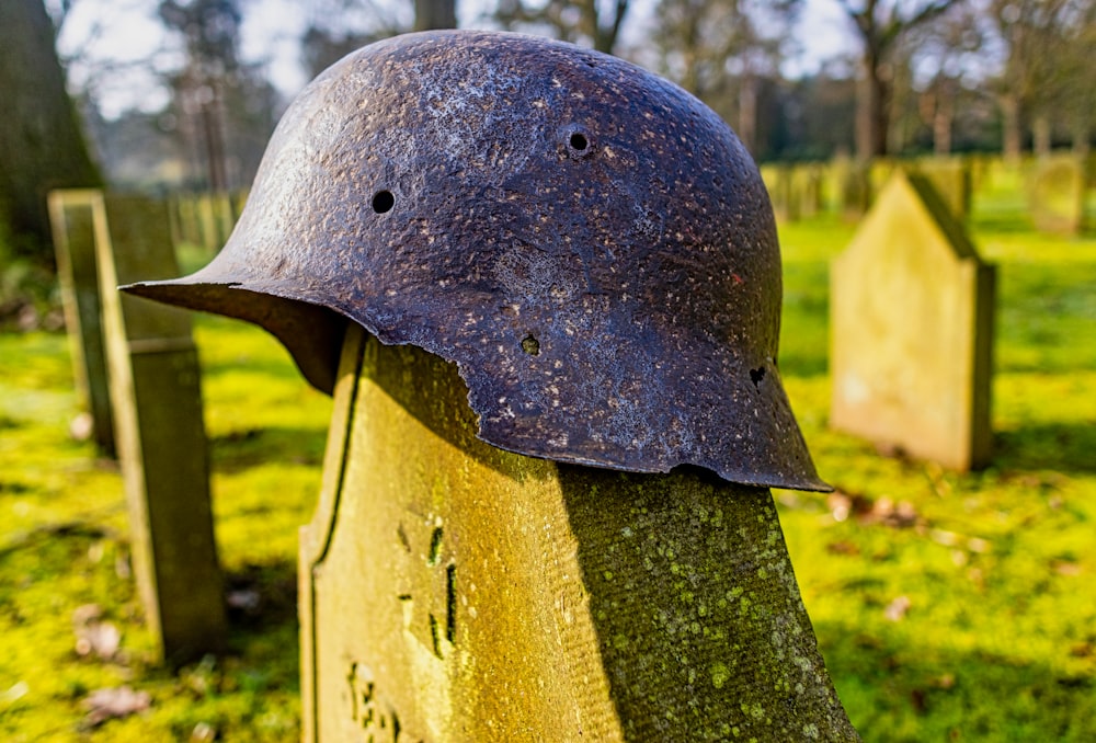 a helmet sitting on top of a stone in a field