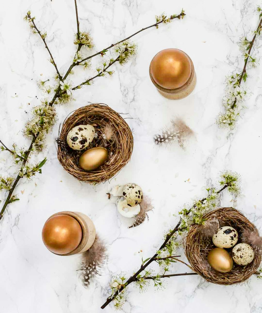 a marble table topped with two birds nests filled with eggs