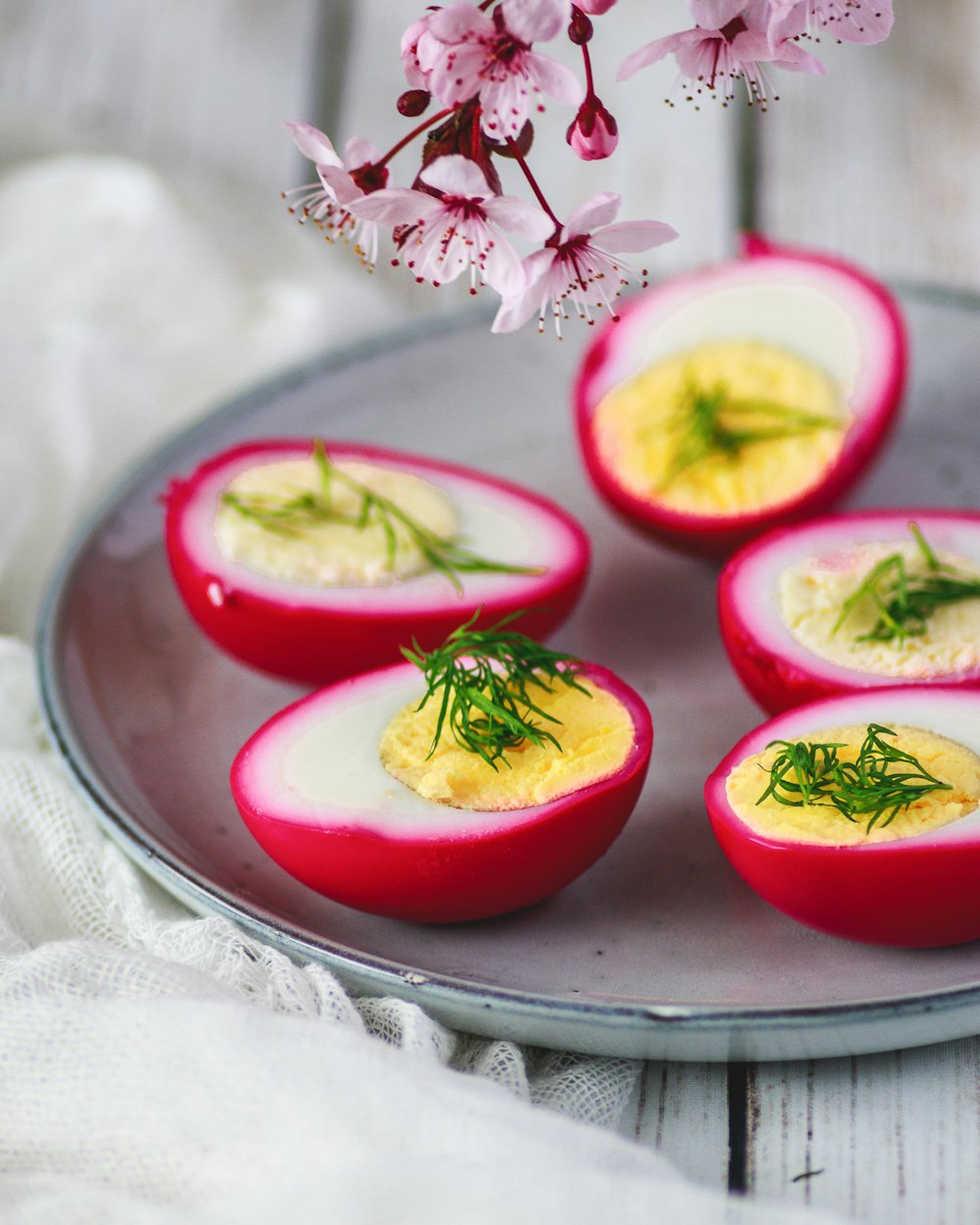 a plate of deviled eggs with dill on top