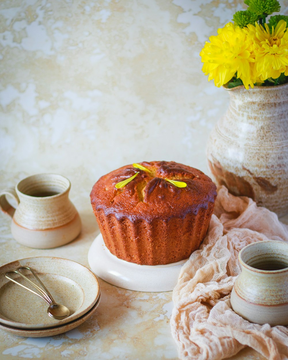 a muffin sitting on top of a white plate next to a cup of coffee