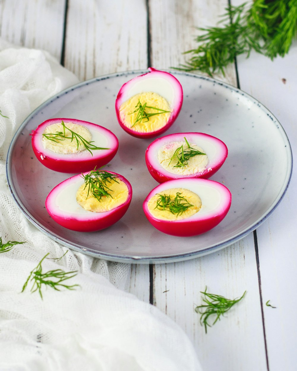 a plate of deviled eggs with dill on top