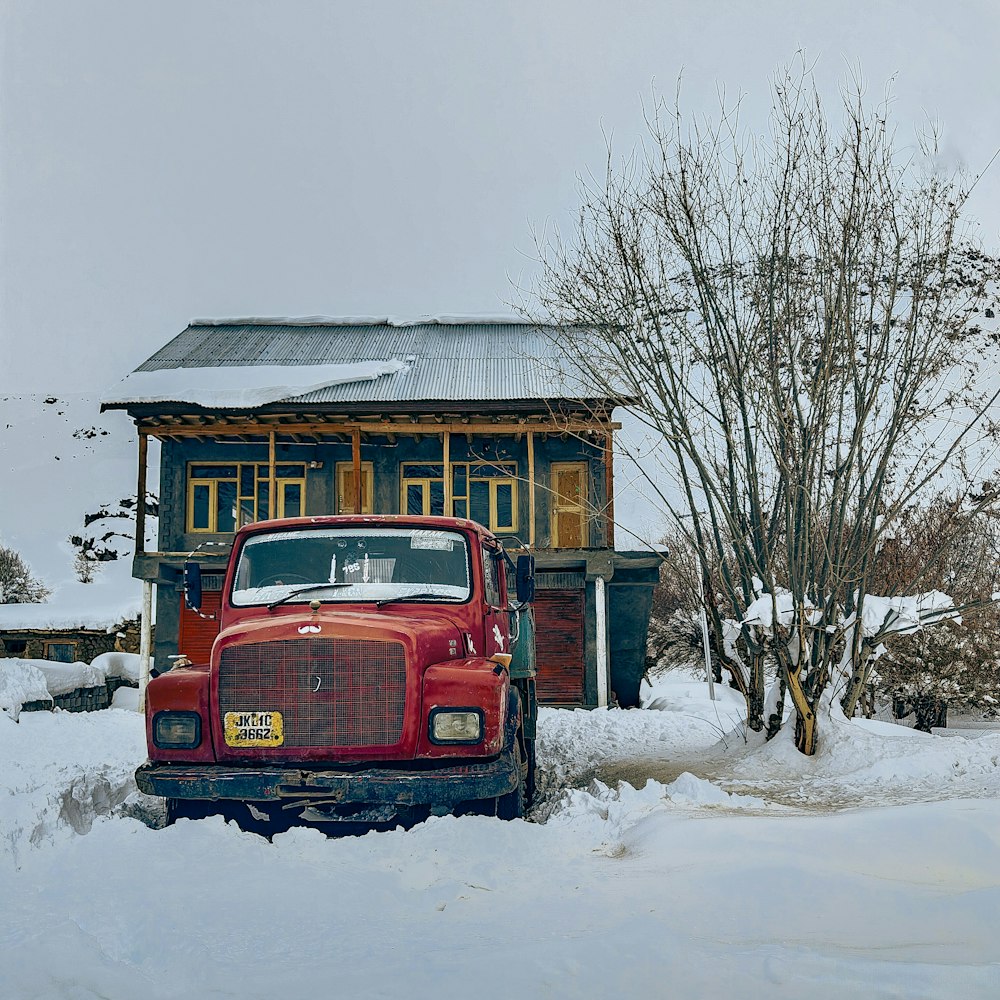 a red truck is parked in the snow