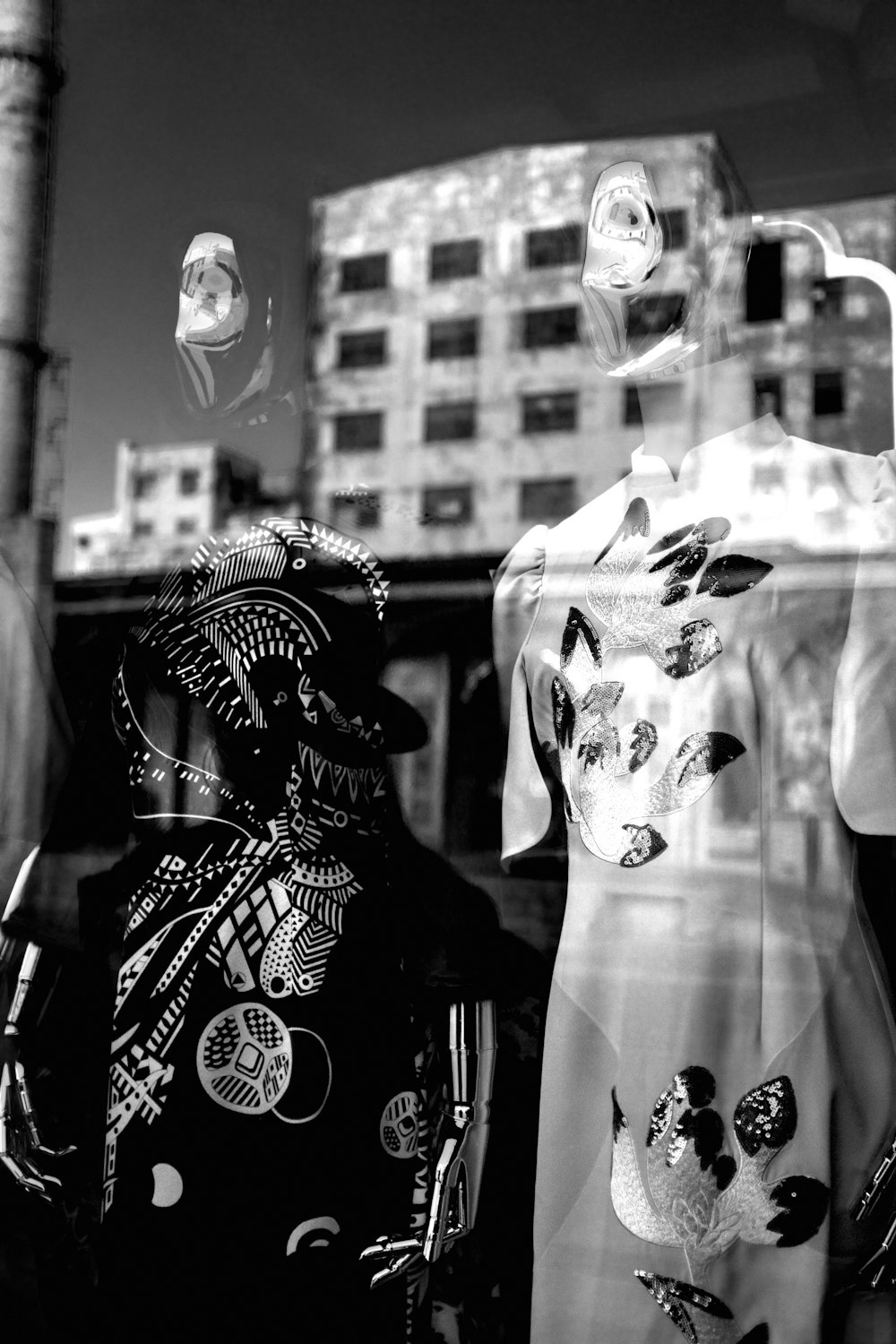 a black and white photo of two mannequins in a window