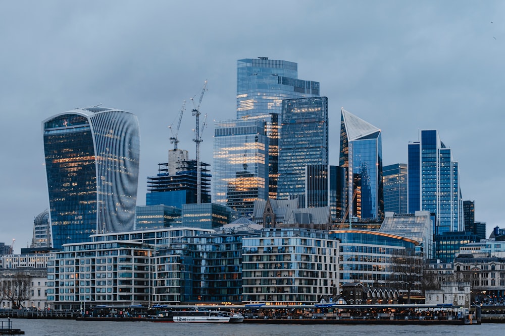 a city skyline with tall buildings and a boat in the water