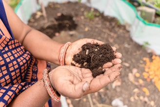 a woman holding a handful of dirt in her hands