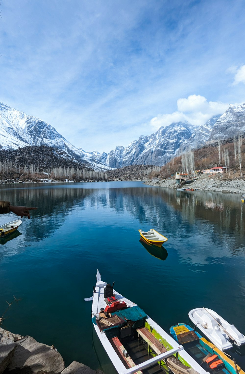 a body of water surrounded by snow covered mountains