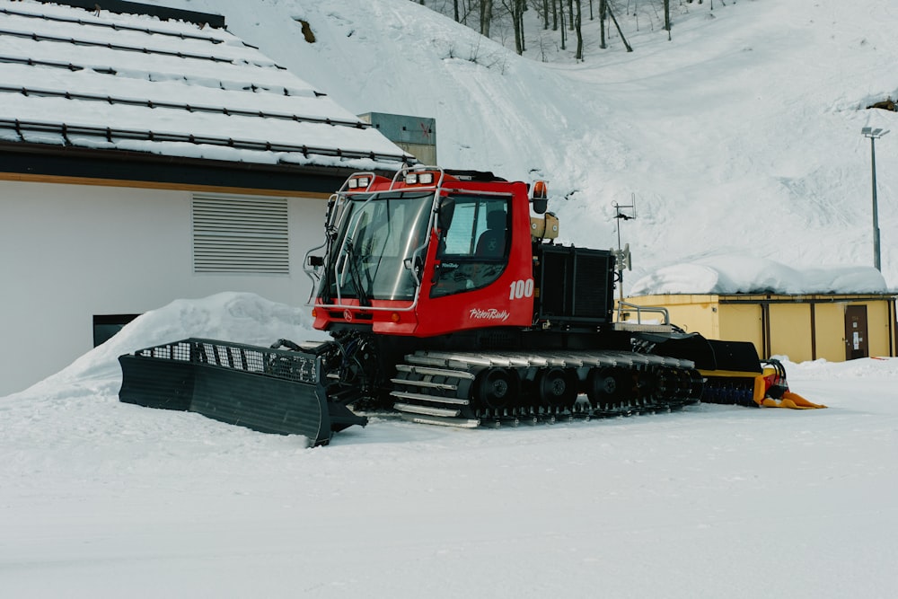 a red tractor is parked in the snow