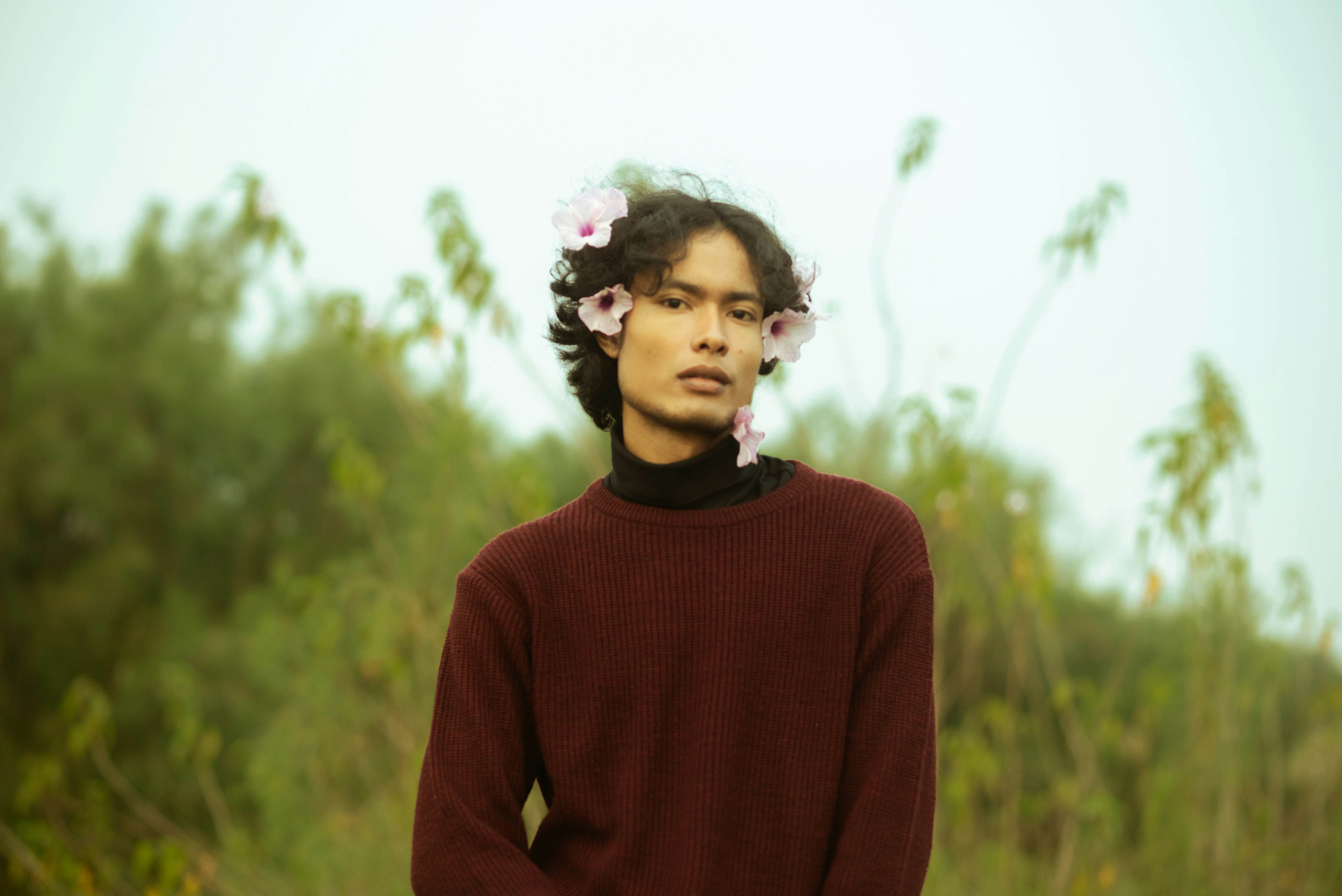a man with a flower in his hair