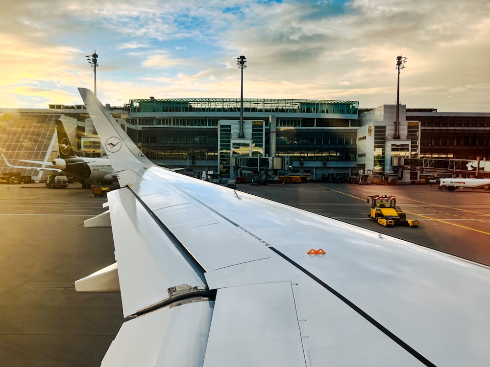 the wing of an airplane with a building in the background