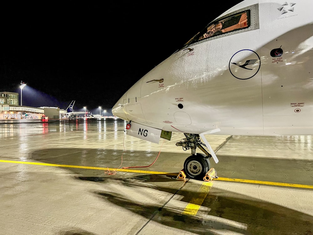 an airplane is parked on the tarmac at night