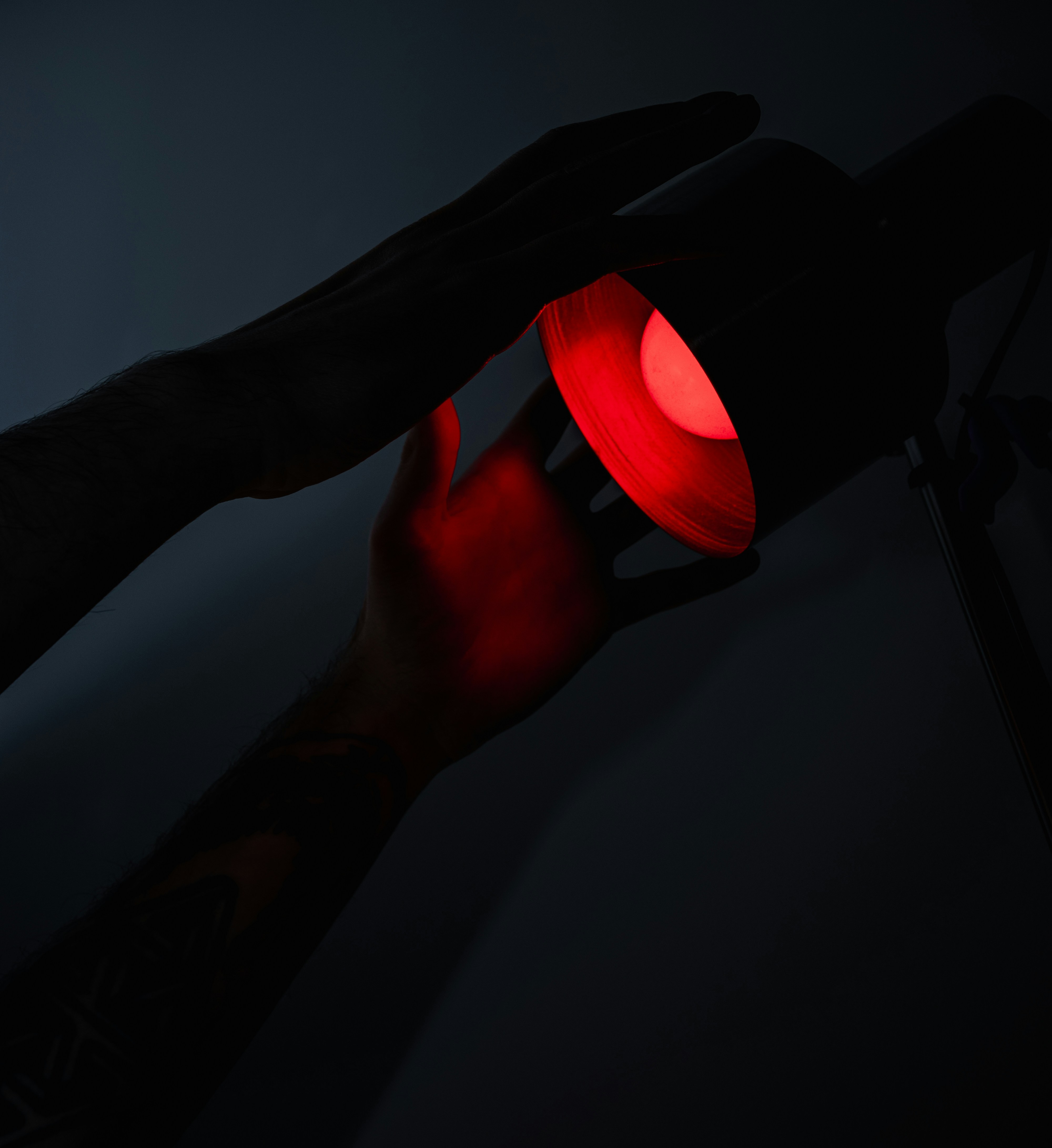 a hand holding a red traffic light in the dark