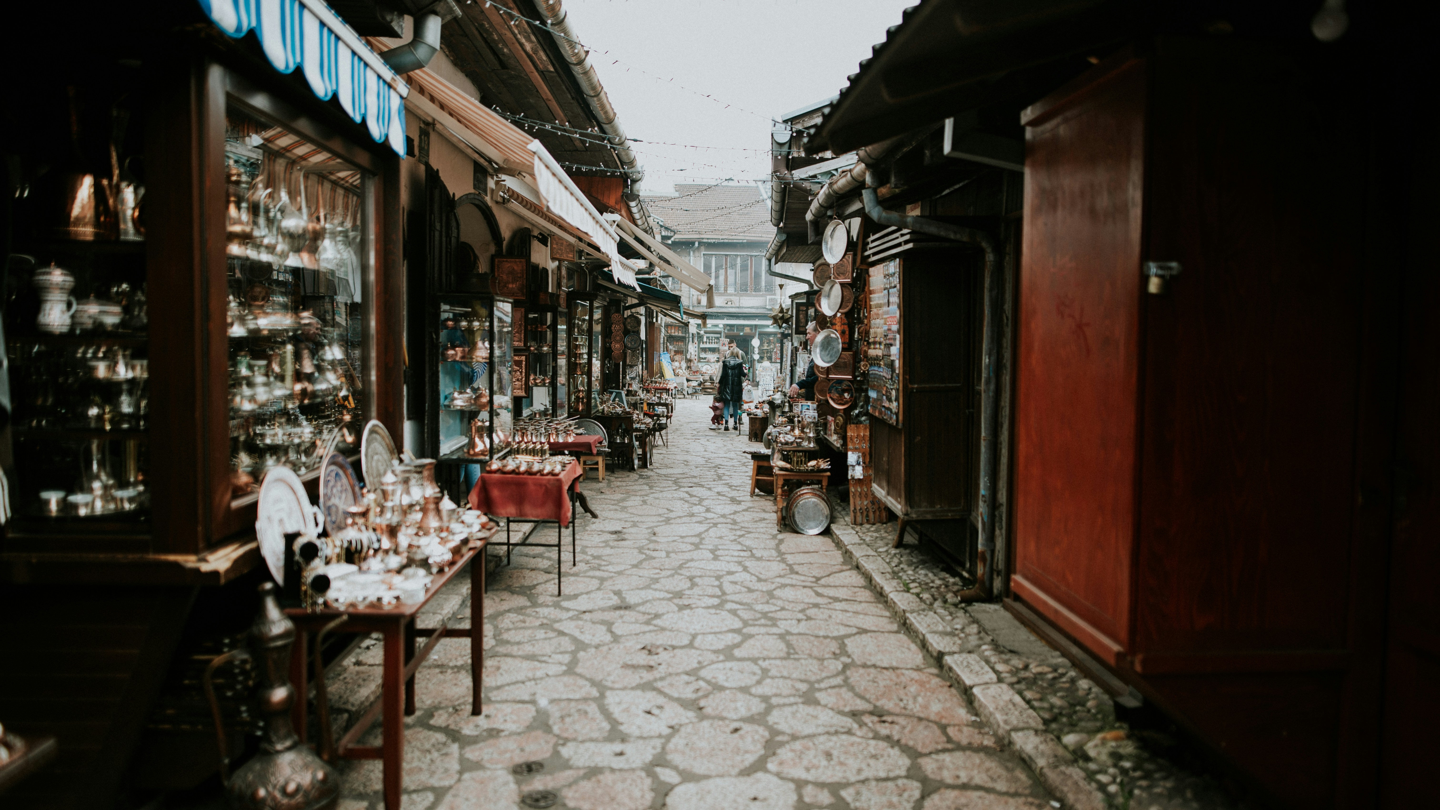 a narrow street lined with shops and vendors, 