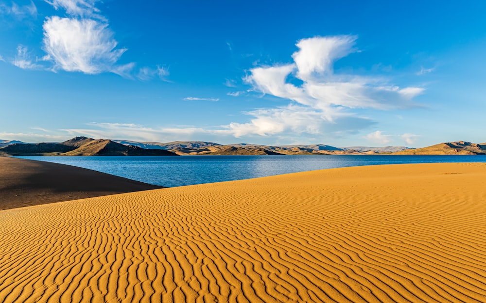 a large body of water surrounded by sand dunes