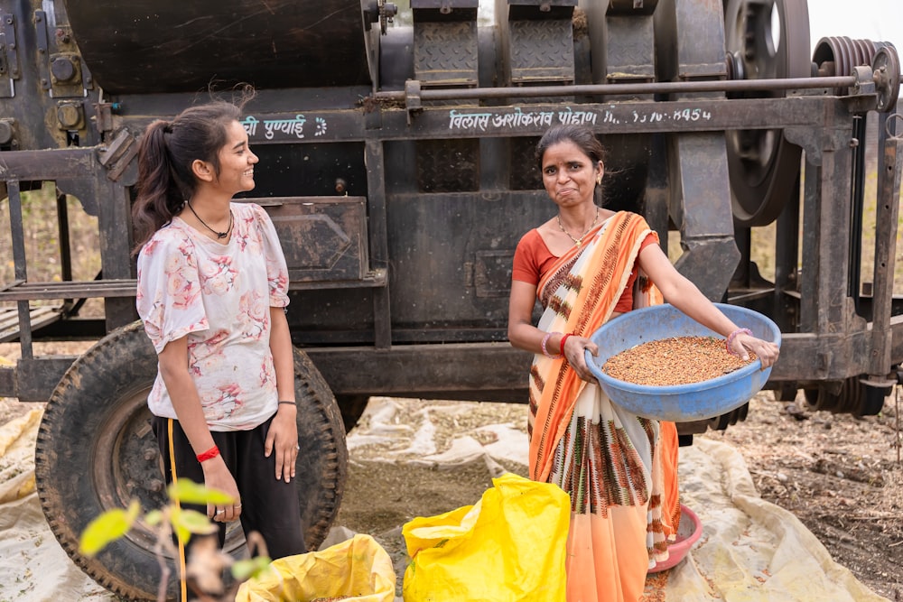 a couple of women standing next to a truck