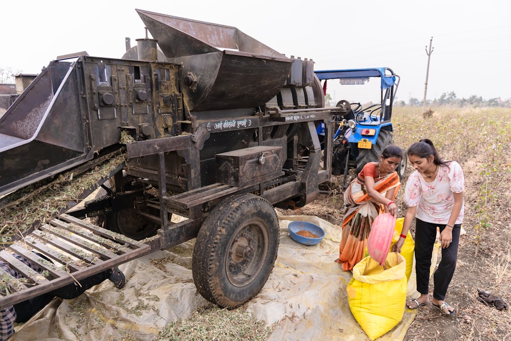 a couple of women standing next to a dump truck