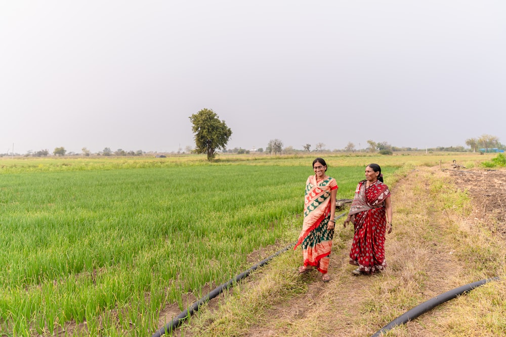 a couple of women standing next to each other in a field