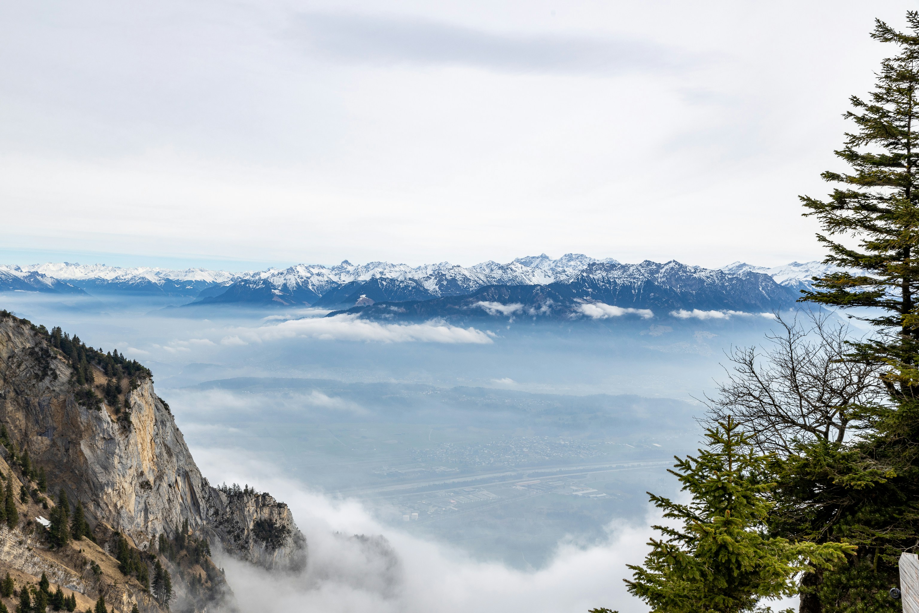 a view of the mountains and clouds from the top of a mountain
