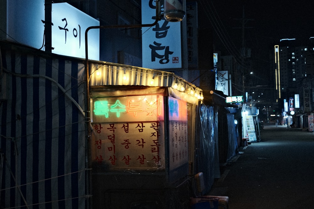 a city street at night with signs lit up