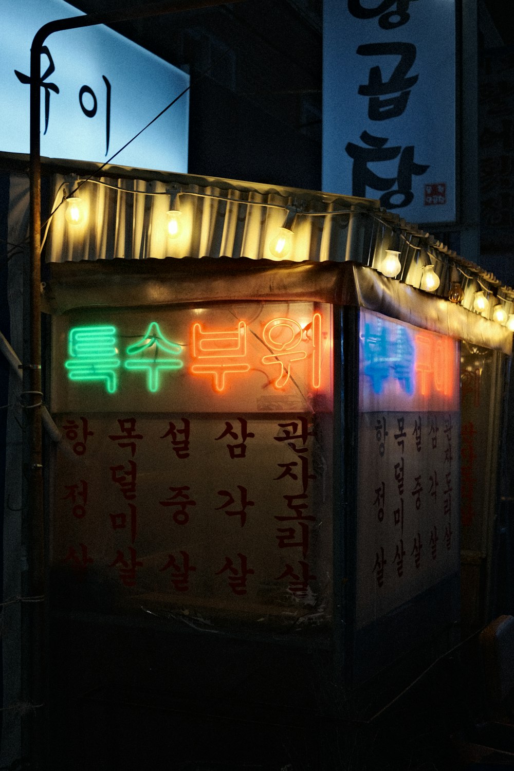 a lit up food stand with asian writing on it