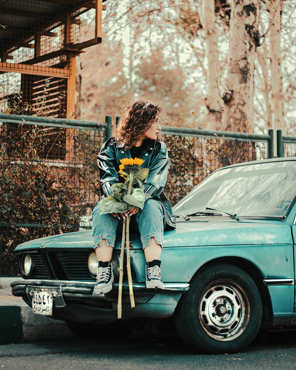 a woman sitting on the hood of a car