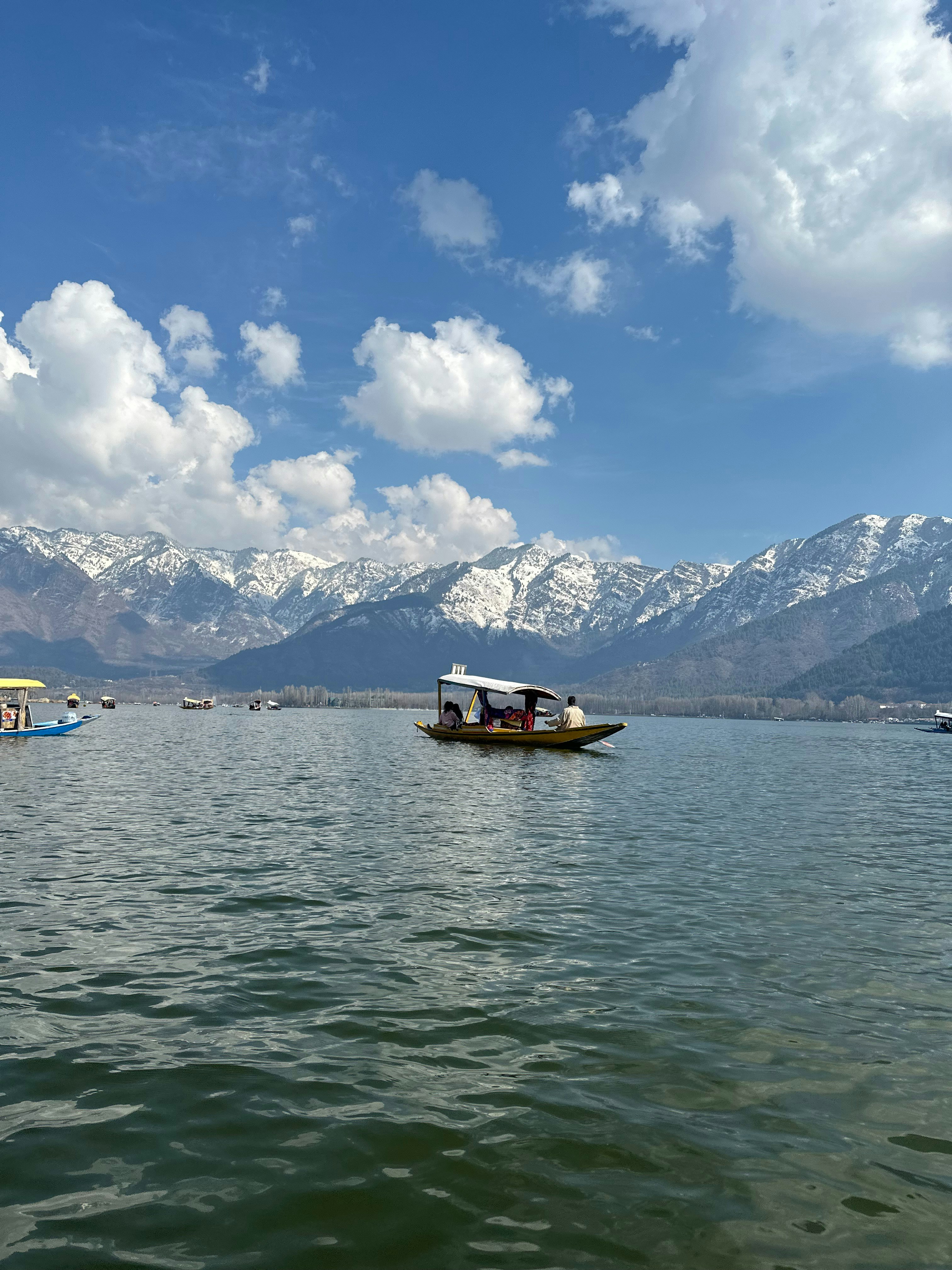 a boat floating on top of a lake under a cloudy sky