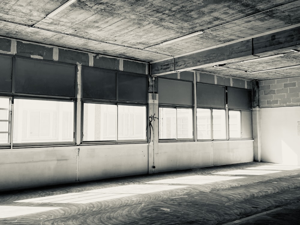 an empty room with windows and a brick wall