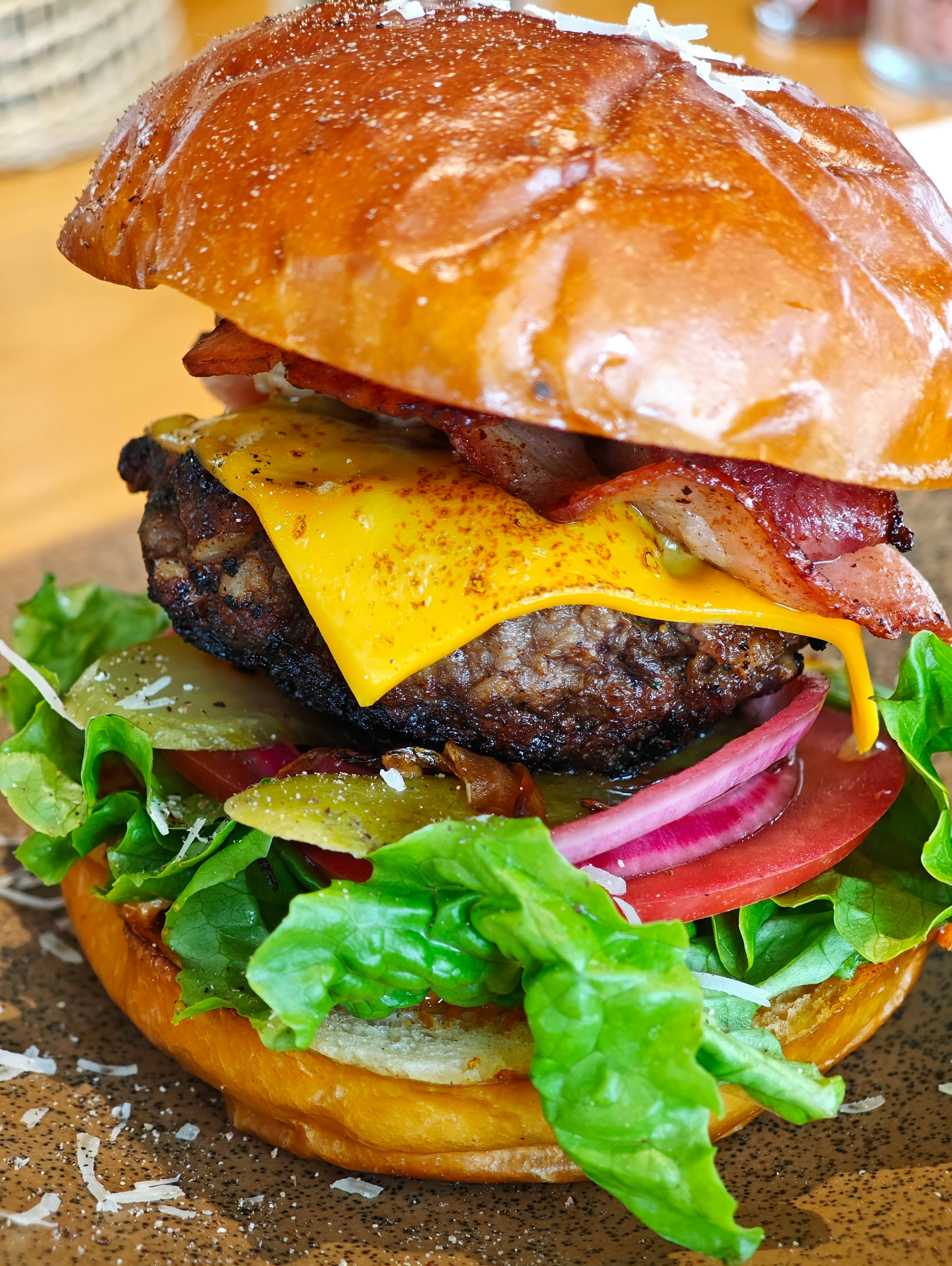 a bacon cheeseburger with lettuce and tomato