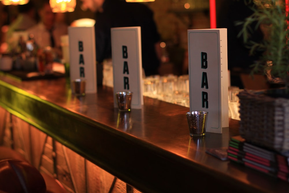 a row of bar signs sitting on top of a bar